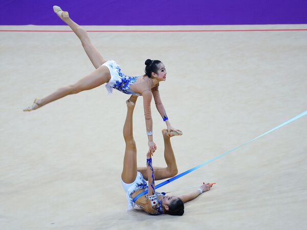 Спортсменки Японии выполняют групповое упражнение с лентами в финале турнира Гран-при Москвы по художественной гимнастике