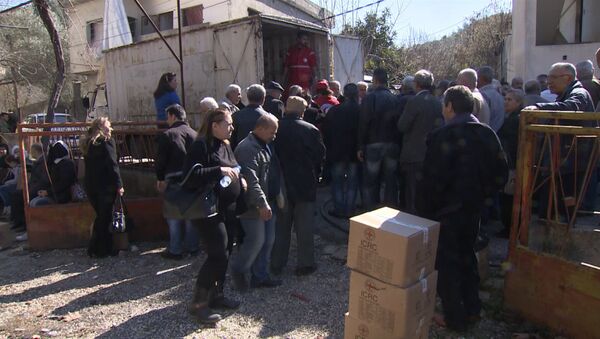 Сирийцы стояли в очереди за коробками гумпомощи с мукой и сахаром в Хомсе