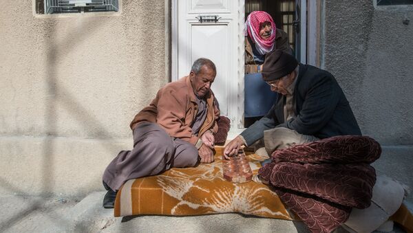 Местные жители у входа в дом в городе Кара в Сирии. Архивное фото