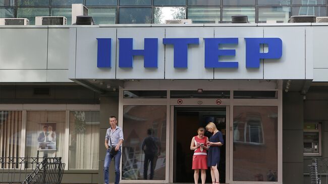 Люди у входа в здание телеканала Интер в Киеве, Украина