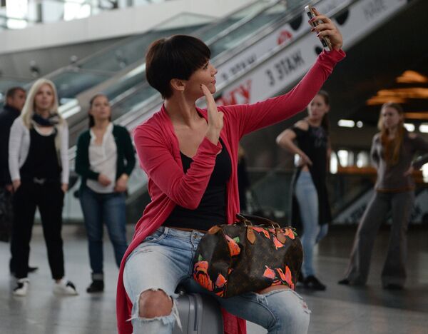 Пассажир фотографируется во время городской танцевальной акции Танцуй, Москва! в аэропорту Внуково