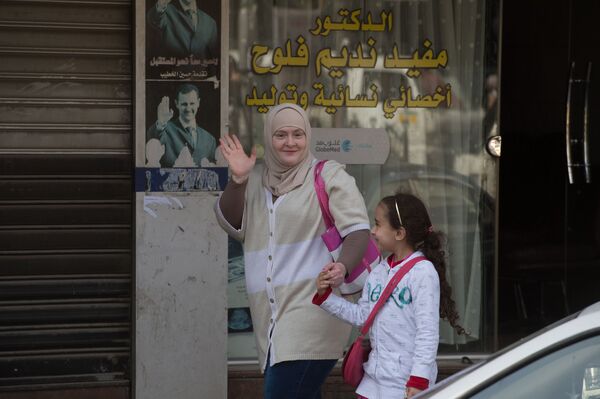 Женщина с ребенком на одной из улиц Дамаска в первый день перемирия