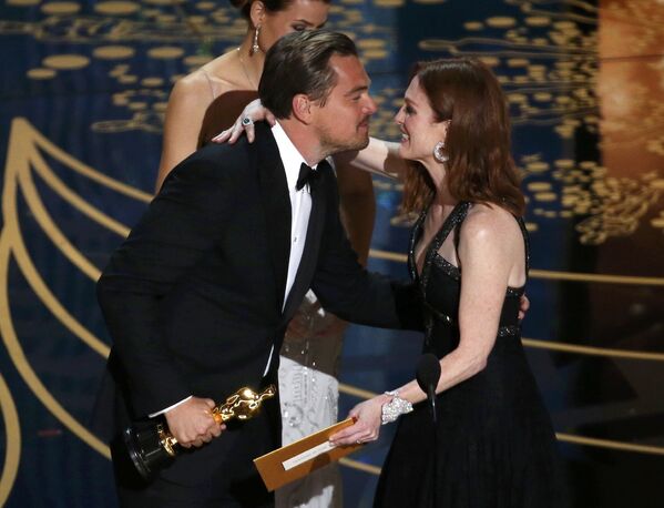 Леонардо Ди Каприо получает премию киноакадемии США Оскар за роль в фильме Выживший из рук актрисы Джулианны Мур