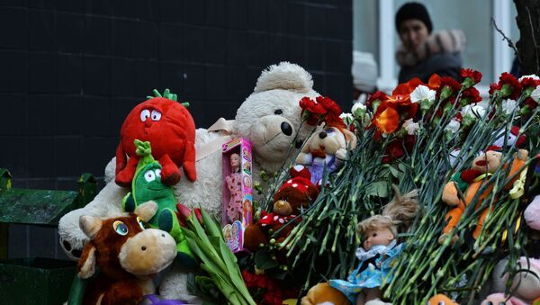 Цветы и игрушки в память об убитой девочке возле подъезда дома на улице Народного ополчения в Москве