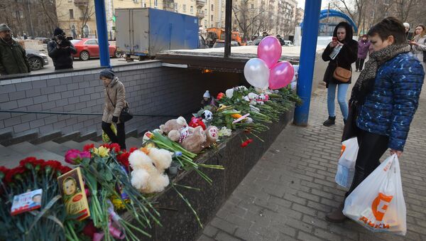 Цветы, свечи и игрушки у метро Октябрьское поле в память о убитой девочке