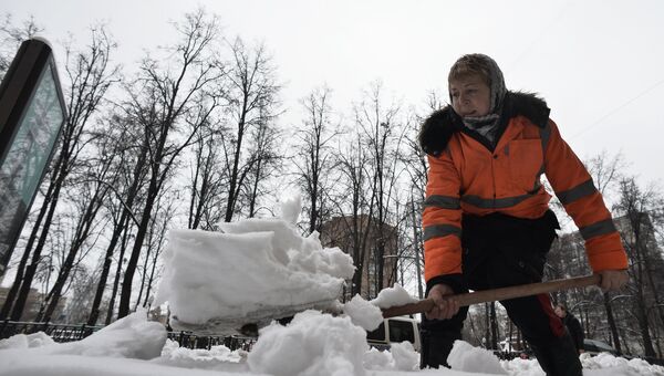 Работница ЖКХ убирает снег