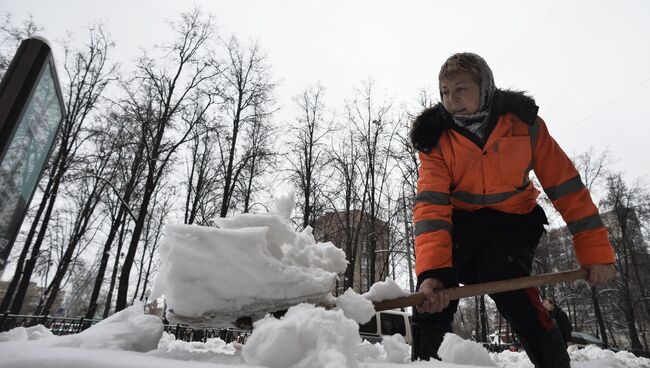 Работница ЖКХ убирает снег на одной из улиц Москвы. Архивное фото