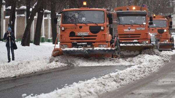 Специальные машины управления жилищно-коммунального хозяйства (ЖКХ) убирают снег на одной из улиц Москвы
