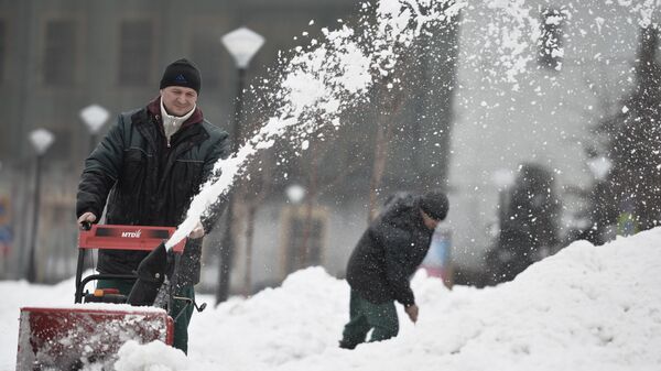 Мужчина убирает снег с помощью снегоуборочной машины после сильного снегопада в Москве