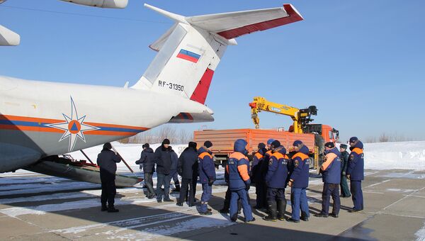 Погрузка оборудования и посадка спасателей МЧС России в самолет, вылетающий на Оху