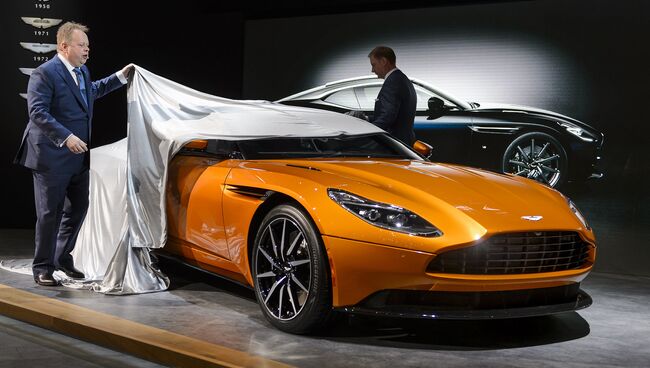 Генеральный директор Aston Martin Энди Палмер с новой моделью автомобиля DB11 на 86-м международном автосалоне в Женеве. Март 2016