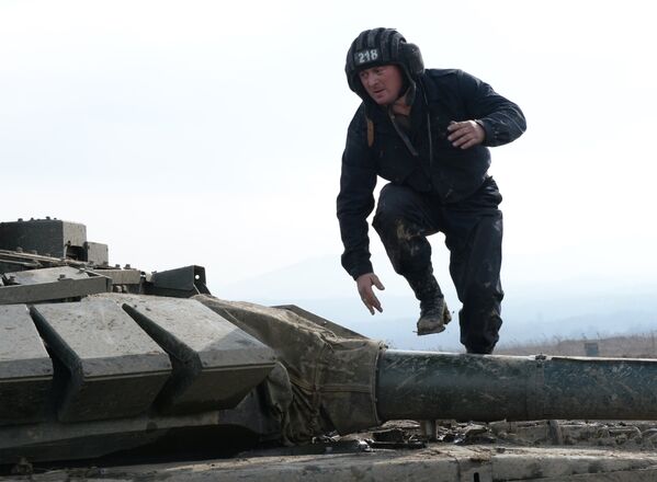 Военнослужащий на броне танка Т-72Б3 17-й отдельной мотострелковой бригады 58-й армии на огневом рубеже во время соревнований по танковому биатлону