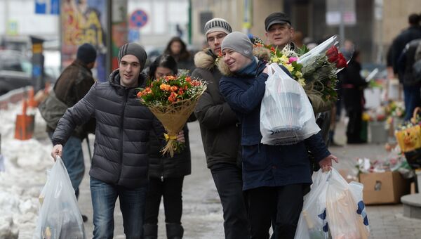 Мужчины с букетами цветов в преддверии праздника 8 марта в Москве
