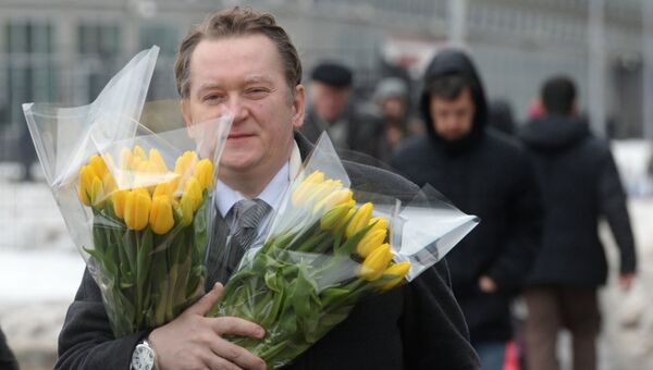 Мужчина с букетами цветов в преддверии праздника 8 марта в Москве