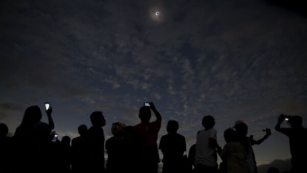 Люди наблюдают за солнечным затмением в Индонезии, 9 марта 2016