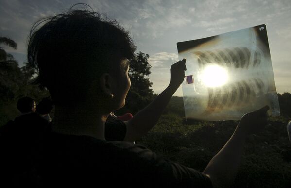 Солнечное затмение, видимое сквозь рентгеновский снимок, Западная Суматра, Индонезия, 9 марта 2016