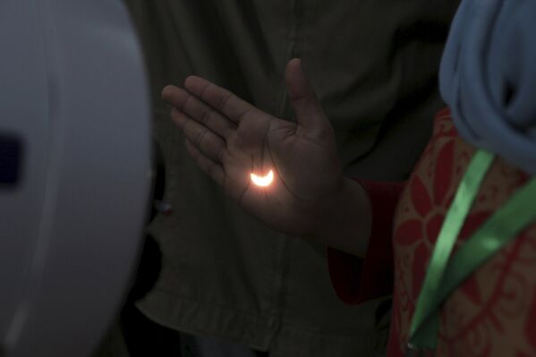 Солнечное затмение, отраженное телескопом на руке. Южная Суматра, Индонезия 9 марта 2016