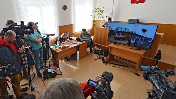 Журналисты смотрят на экране монитора трансляцию заседания по делу украинской летчицы Надежды Савченко