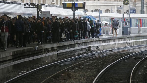 Люди ждут пригородный поезд на железнодорожном вокзале Сент-Лазар в Париже, Франция. 9 марта 2016