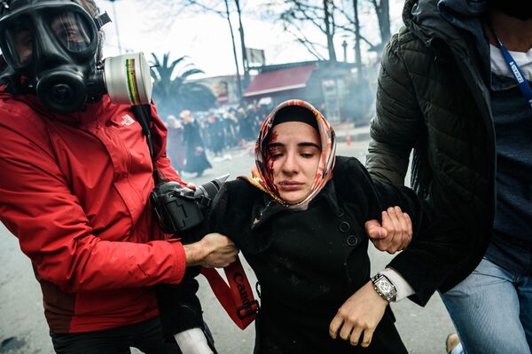 Журналисты ведут раненую во время столкновений с полицией женщину в Стамбуле, Турция