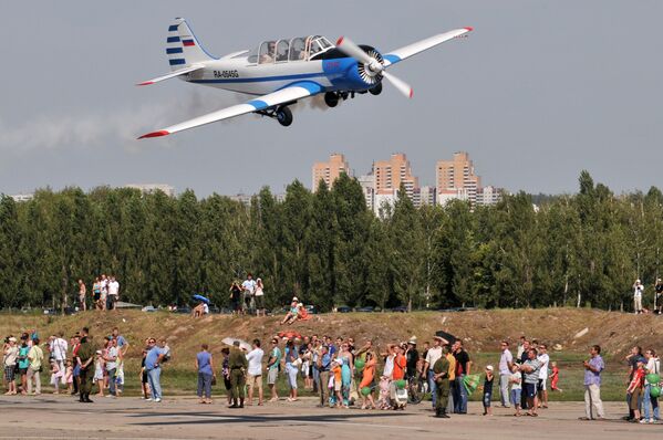 Самолет Як-52 пролетает над зрителями во время праздничных мероприятий, посвященных Дню Военно-воздушных сил и 70-летию образования авиационной базы