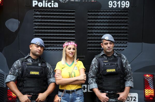 Участница демонстрации фотографируется с полицейскими в городе Сан-Паулу, Бразилия