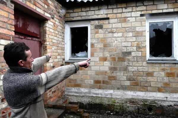 Местный житель показывает разрушения своего дома в поселке Зайцево под Горловкой