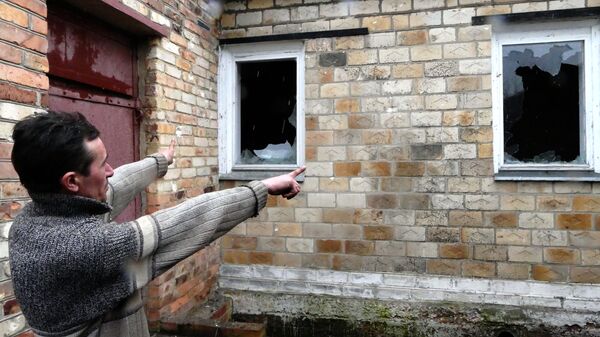 Местный житель показывает разрушения своего дома в поселке Зайцево под Горловкой