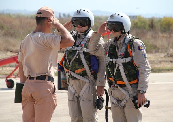 Российские летчики принимают рапорт у командира техников перед полетом на авиабазе Хмеймим в Сирии