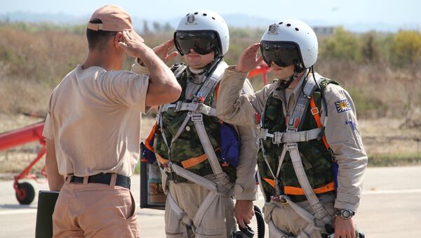 Российские летчики принимают рапорт у командира техников перед полетом на авиабазе Хмеймим в Сирии