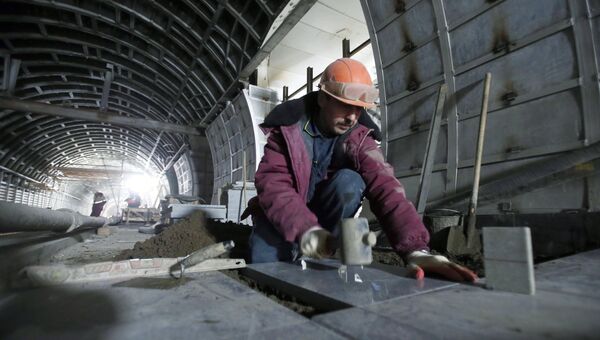 Рабочий укладывает плитку на будущей платформе в ходе строительства станции Фонвизинская Люблинско-Дмитровской линии