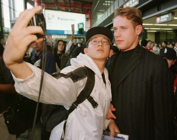 Японский болельщик фотографируется с хоккеистом Павлом Буре в Токио. 30 сентября 1997