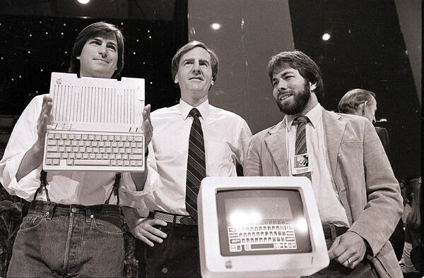 Стив Джобс, Джон Скалли и Стив Возняк во время презентации нового компьютера компании Apple в Сан-Франциско, США. 24 апреля 1984