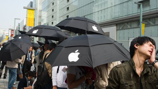 Люди стоят в очереди у Apple Store в Токио в ожидании начала продаж iPhone 4S