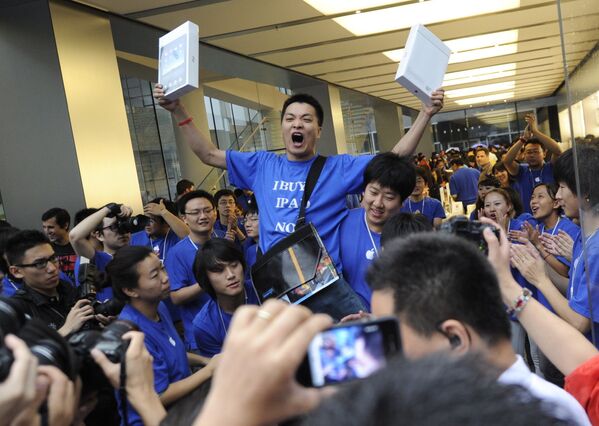 Покупатель радуется приобретению планшетов компании Apple в Пекине, Китай