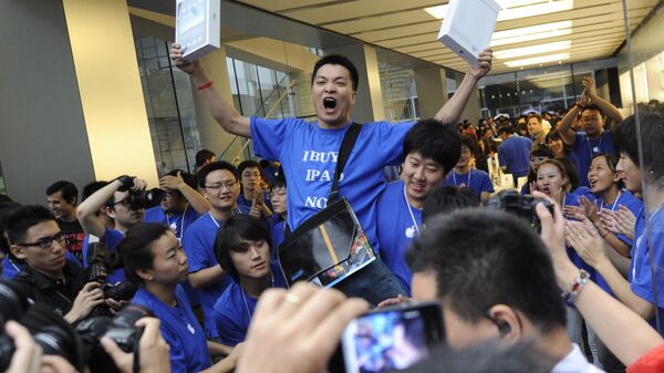 Покупатель радуется приобретению планшетов компании Apple в Пекине, Китай. Архивное фото