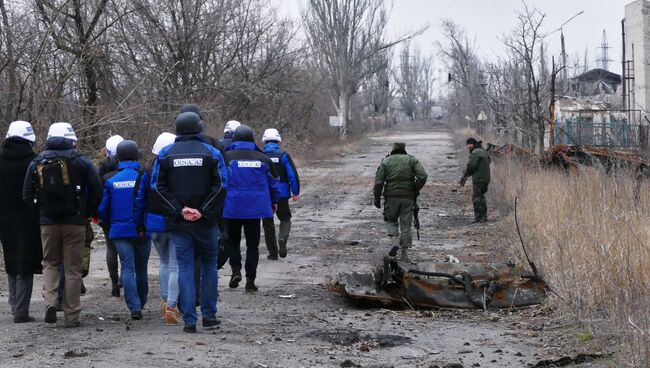 Сотрудники ОБСЕ (слева) во время посещения района обстрелов на Ясиноватской развилке в Донецкой области. Архивное фото