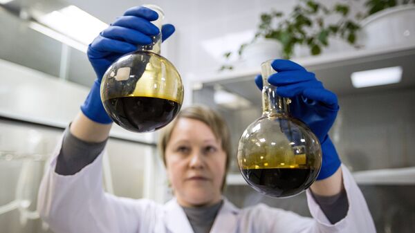 Лаборант отбирает пробы нефти