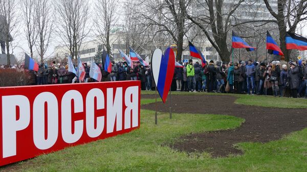 Жители Донецка на митинге-концерте, посвященном годовщине воссоединения Крыма с Россией, прошедшем в Первомайском сквере на центральной площади города