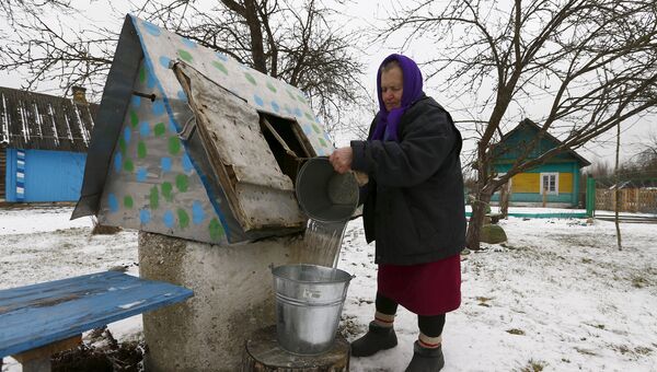 Женщина набирает воду из колодца в Белоруссии. Архивное фото
