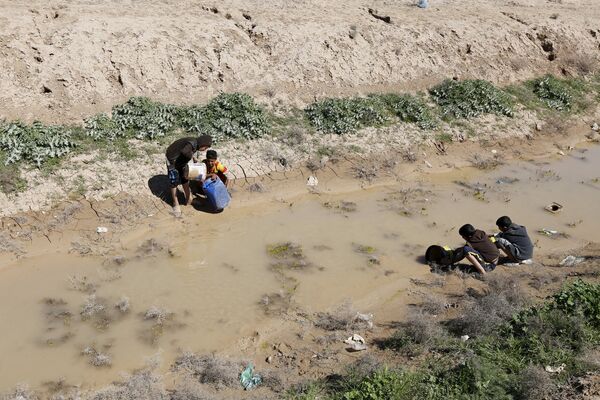 Дети набирают воду из реки в Багдаде, Ирак
