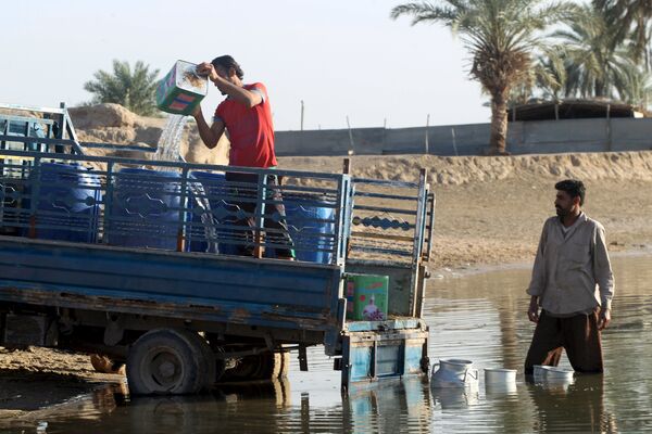 Люди собирают воду в реке. Багдад, Ирак