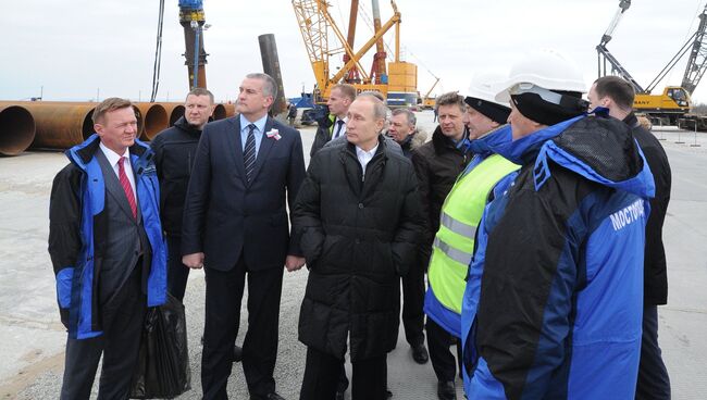 Президент России Владимир Путин (в центре) во время посещения строительной площадки транспортного перехода через Керченский пролив, 18 марта 2016