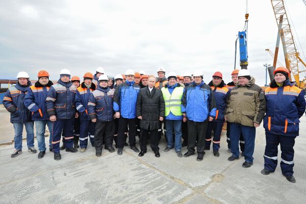 Президент России Владимир Путин с рабочими во время посещения строительной площадки транспортного перехода через Керченский пролив на острове Тузла