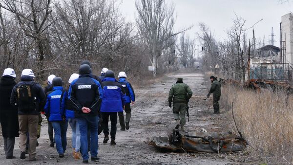 Сотрудники ОБСЕ (слева) во время посещения района обстрелов на Ясиноватской развилке в Донецкой области