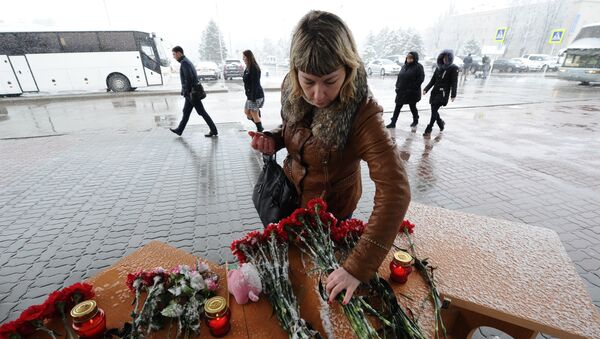 Женщина возлагает цветы у аэропорта Ростова-на-Дону, где при посадке разбился пассажирский самолет Boeing-737-800