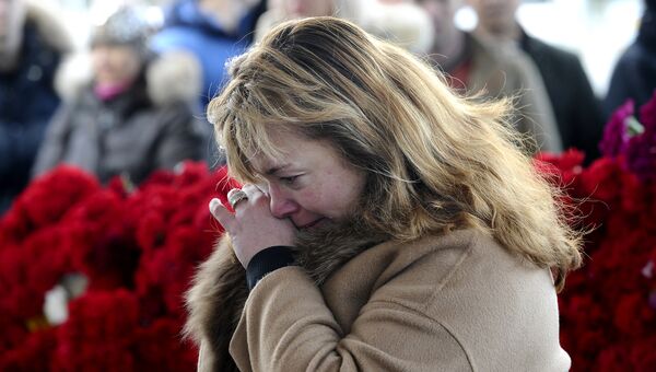 Женщина возлагает цветы у аэропорта Ростова-на-Дону, где при посадке разбился пассажирский самолет Boeing-737-800