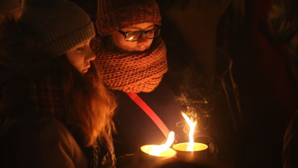 Участники акции на стрелке Васильевского острова в Санкт-Петербурге зажигают свечи в память о погибших в авиакатастрофе Boeing-737-800 в Ростове-на-Дону