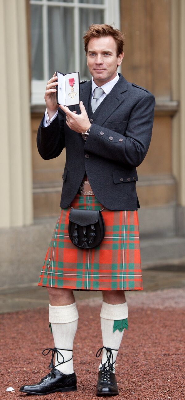 Актер Юэн МакГрегор держит Превосходнейший орден Британской империи, полученный из рук принца Чарльза, в Лондоне, Великобритания