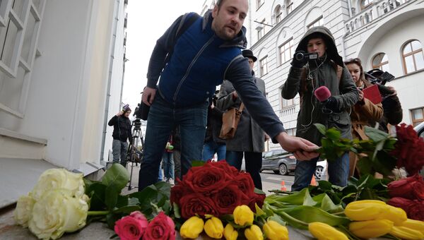 Мужчина возлагает цветы у посольства Бельгии в Москве
